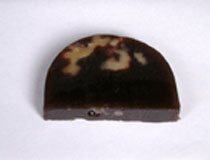 半円の形をした奄美大島で採れる黒糖（大島糖）と信州の胡桃が入った月影